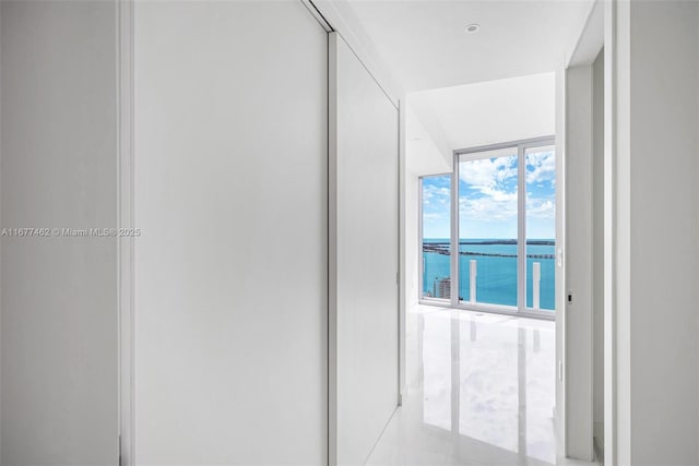 hallway with a water view and floor to ceiling windows