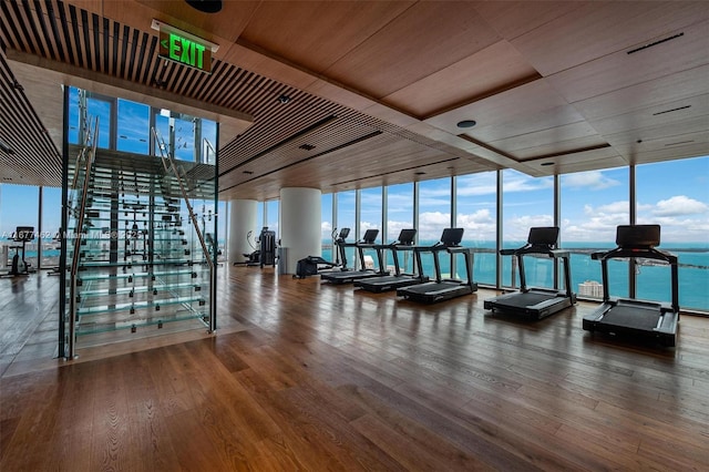 workout area featuring wood ceiling, expansive windows, and wood finished floors