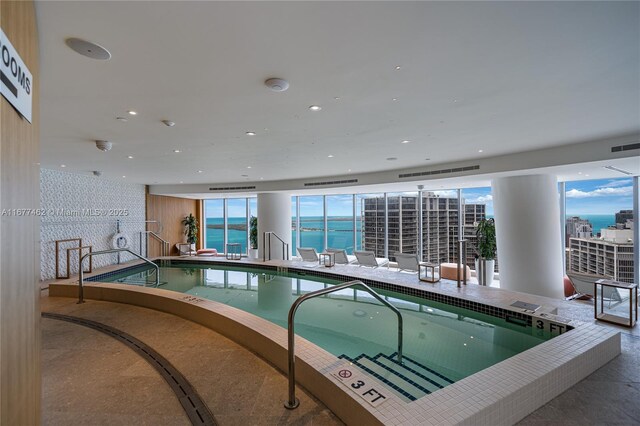 view of pool featuring a water view and a hot tub