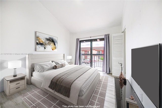 bedroom with lofted ceiling, access to exterior, and light hardwood / wood-style flooring