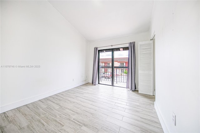 empty room featuring lofted ceiling and light wood-type flooring