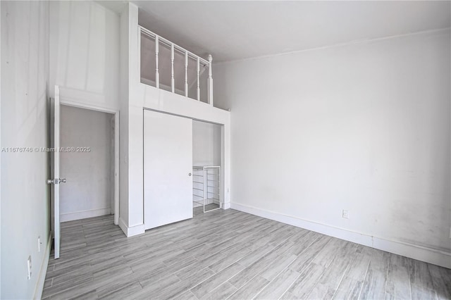 unfurnished bedroom with light hardwood / wood-style floors and a closet