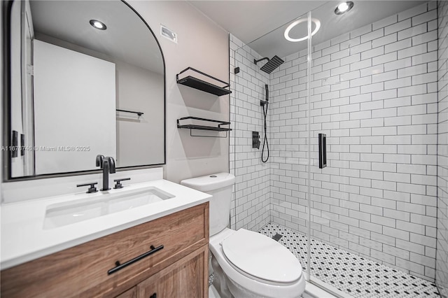 bathroom featuring vanity, an enclosed shower, and toilet