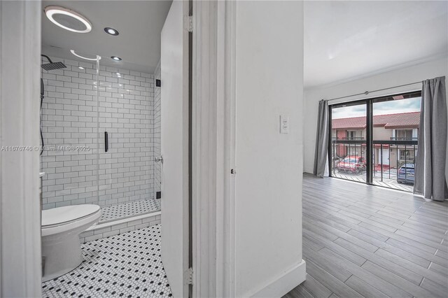 bathroom featuring walk in shower, toilet, and hardwood / wood-style floors