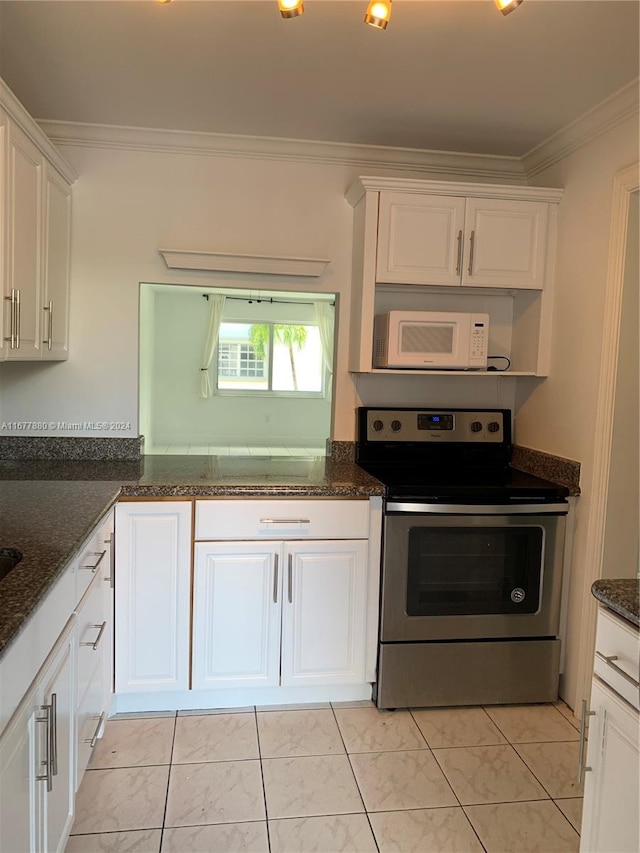 kitchen with ornamental molding, white cabinets, dark stone countertops, and electric stove