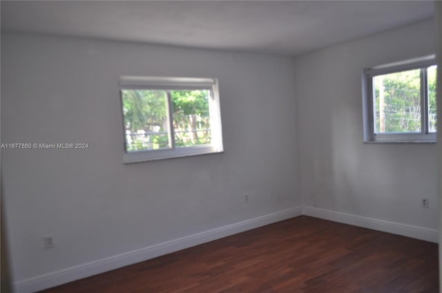 unfurnished room with dark wood-type flooring and plenty of natural light