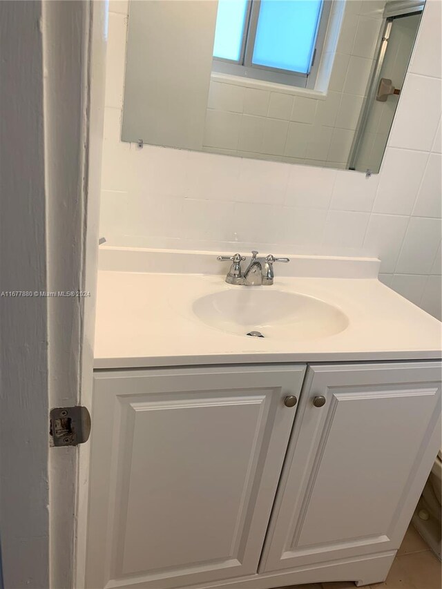 bathroom featuring vanity and decorative backsplash