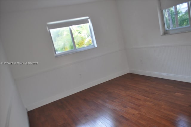 251 Galen Dr Unit 204E, Key Biscayne, FL 33149 - empty room with healthy amount of natural light, dark wood-type flooring, and wainscoting