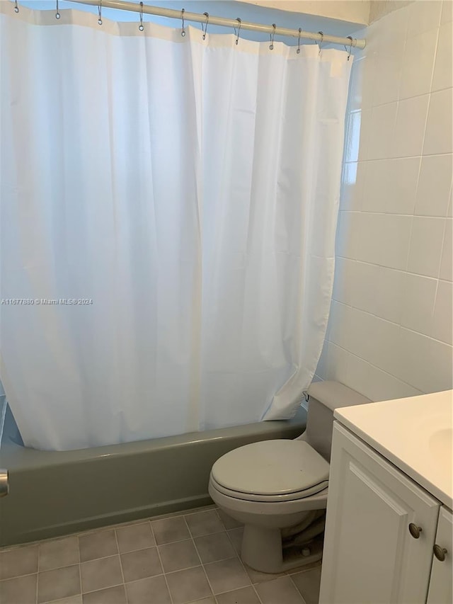 full bathroom featuring shower / bathtub combination with curtain, tile walls, toilet, vanity, and tile patterned floors