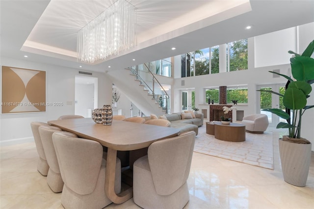 dining room featuring a high ceiling, a chandelier, and a tray ceiling