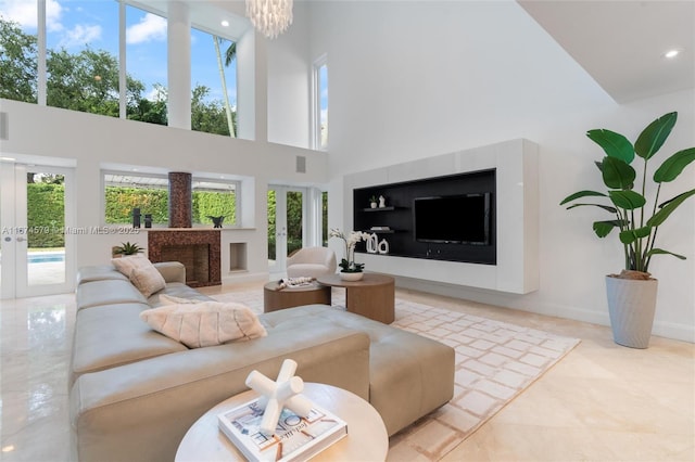 living room with french doors, a towering ceiling, and a chandelier