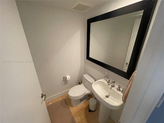 bathroom featuring toilet, hardwood / wood-style flooring, and sink