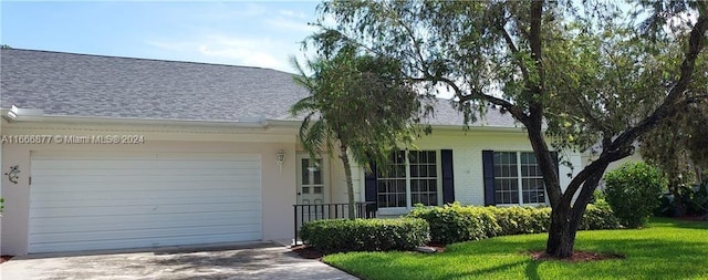 view of front of home with a front yard and a garage