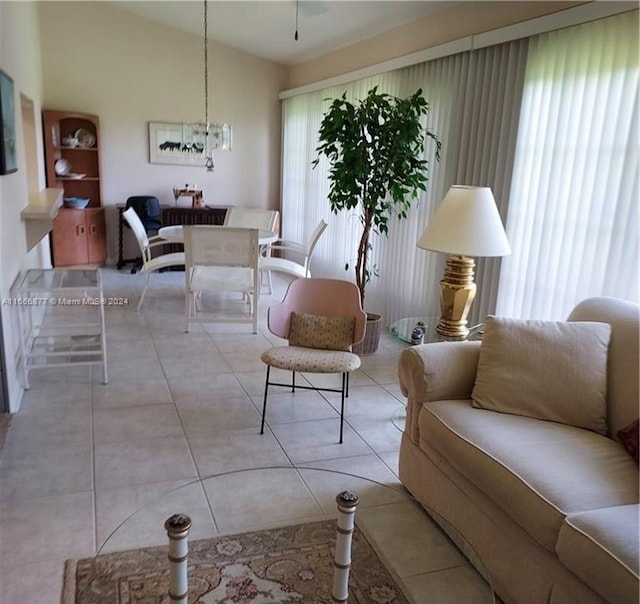 living room featuring light tile patterned flooring, a chandelier, and vaulted ceiling