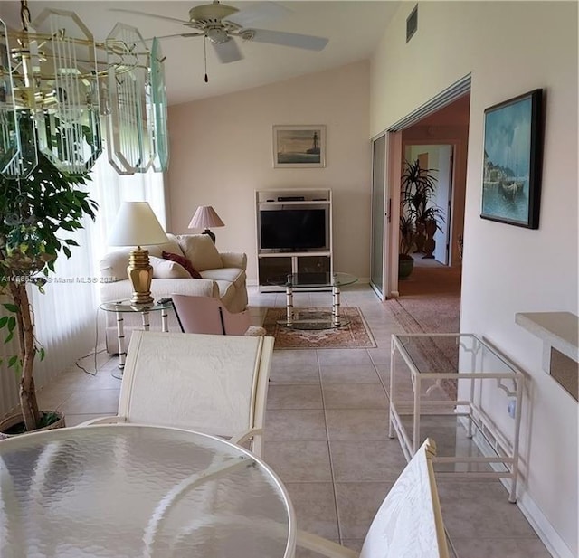 living room featuring ceiling fan, vaulted ceiling, and light tile patterned floors