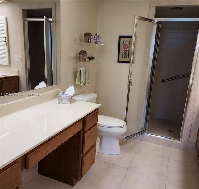 bathroom with vanity, toilet, tile patterned floors, and a shower with door