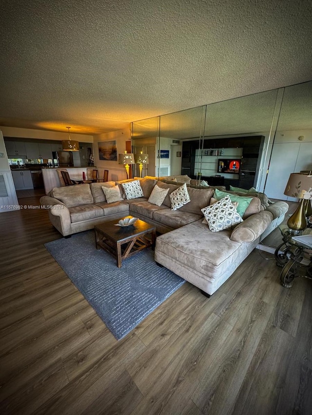 living room with dark wood-type flooring and a textured ceiling