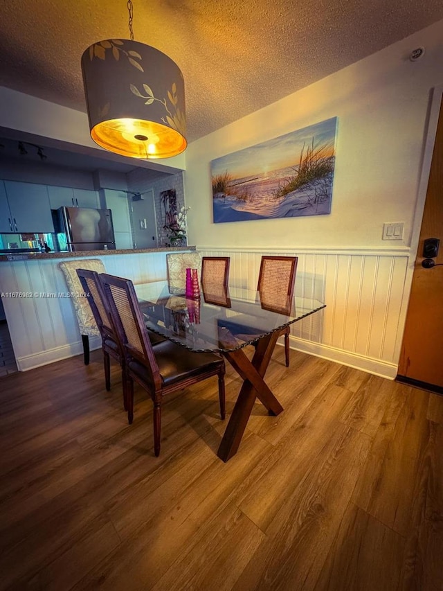 dining room featuring a textured ceiling, hardwood / wood-style flooring, and breakfast area