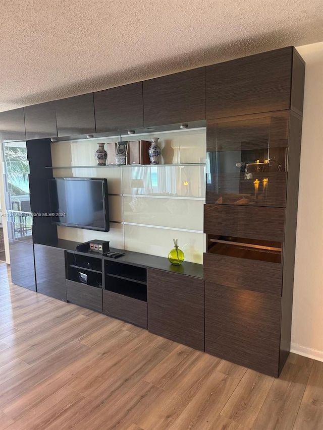 kitchen featuring dark brown cabinets, a textured ceiling, and wood-type flooring