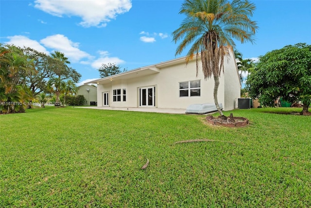 rear view of property featuring a patio, cooling unit, and a lawn