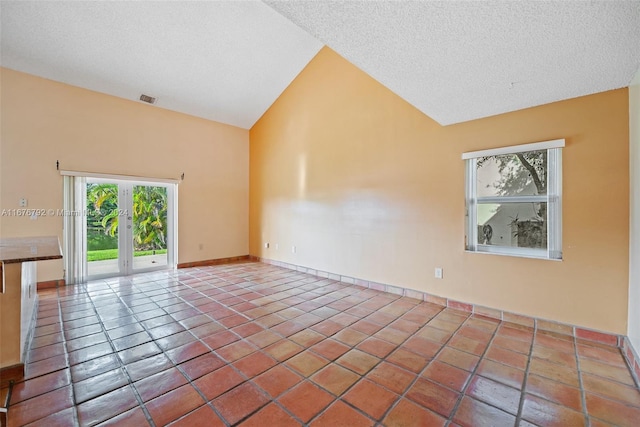 spare room featuring tile patterned floors, a textured ceiling, and high vaulted ceiling