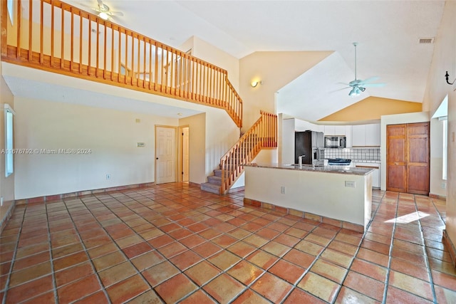 kitchen featuring tasteful backsplash, white cabinetry, ceiling fan, stainless steel appliances, and high vaulted ceiling