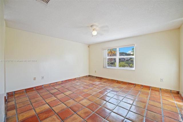 tiled spare room featuring ceiling fan and a textured ceiling