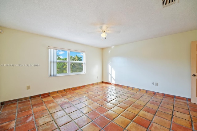 tiled spare room with a textured ceiling and ceiling fan