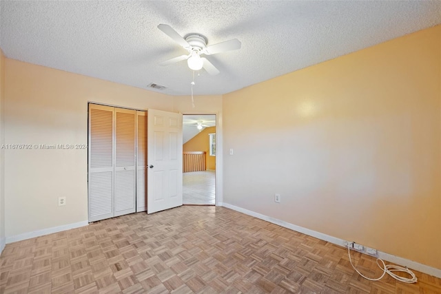 unfurnished bedroom with a closet, ceiling fan, light parquet flooring, and a textured ceiling