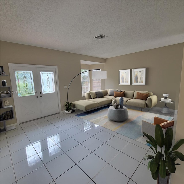 living room featuring a textured ceiling and light tile patterned floors