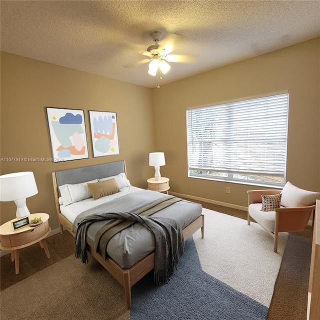 bedroom featuring ceiling fan, a textured ceiling, and carpet flooring