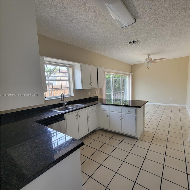 kitchen featuring white cabinetry, kitchen peninsula, a healthy amount of sunlight, and sink