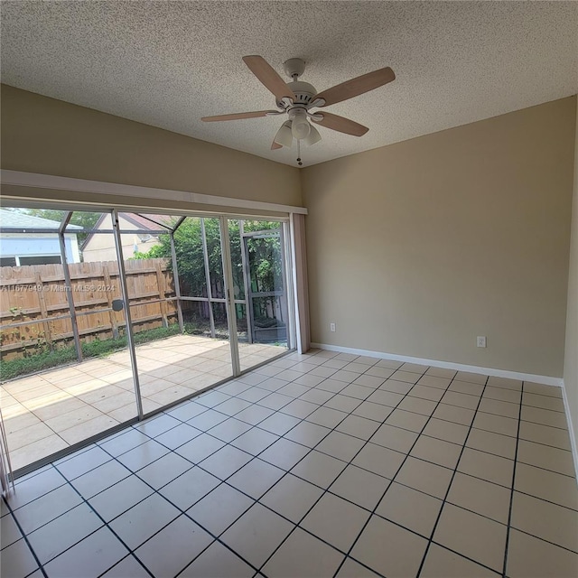 tiled spare room with ceiling fan and a textured ceiling