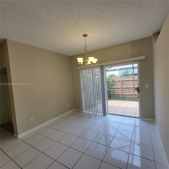 unfurnished dining area with an inviting chandelier, a textured ceiling, and light tile patterned floors