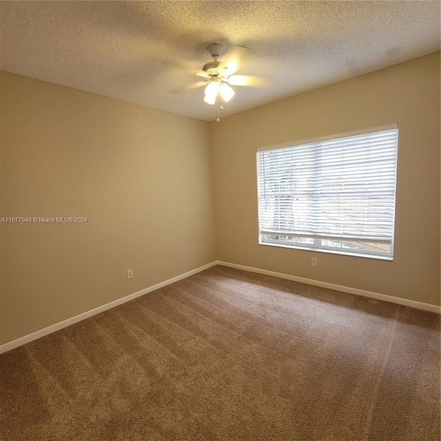 carpeted empty room featuring a textured ceiling and ceiling fan