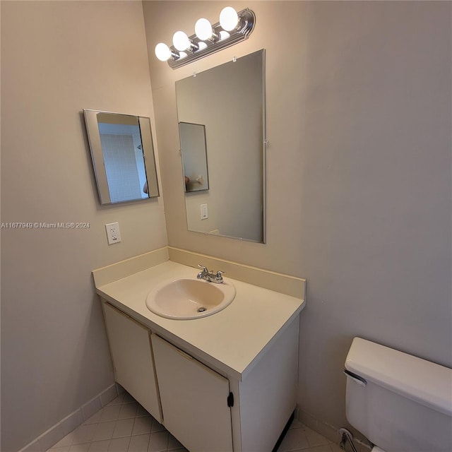 bathroom featuring vanity, tile patterned floors, and toilet