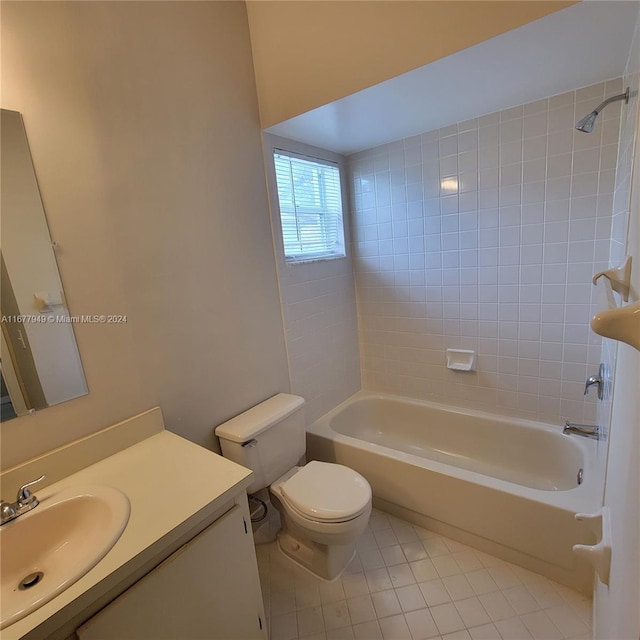 full bathroom featuring toilet, tiled shower / bath combo, vanity, and tile patterned flooring