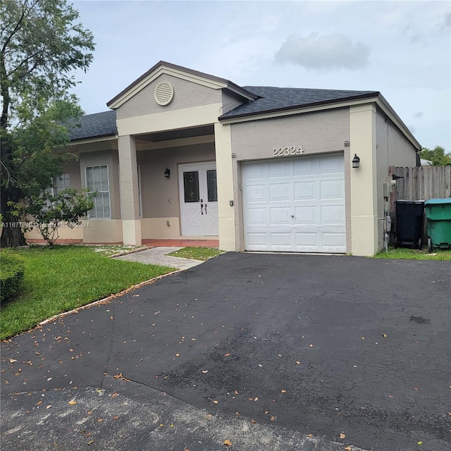 single story home featuring a front lawn and a garage