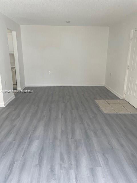 1068NBENOIST Farm Rd Unit 105, West Palm Beach, FL 33411 - unfurnished room featuring wood finished floors and baseboards