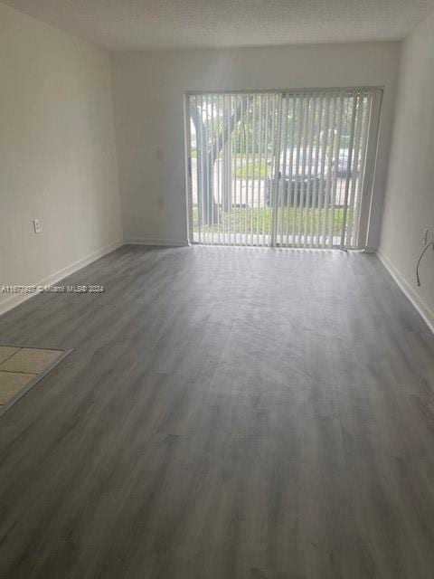 1068NBENOIST Farm Rd Unit 105, West Palm Beach, FL 33411 - empty room with wood finished floors and baseboards