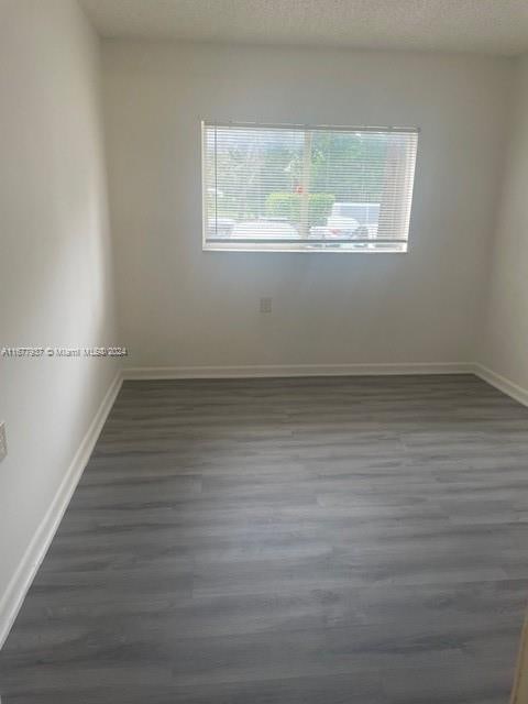 1068NBENOIST Farm Rd Unit 105, West Palm Beach, FL 33411 - unfurnished room with wood finished floors and baseboards