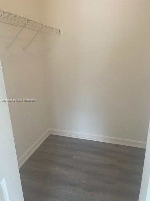 1068NBENOIST Farm Rd Unit 105, West Palm Beach, FL 33411 - walk in closet featuring dark wood finished floors