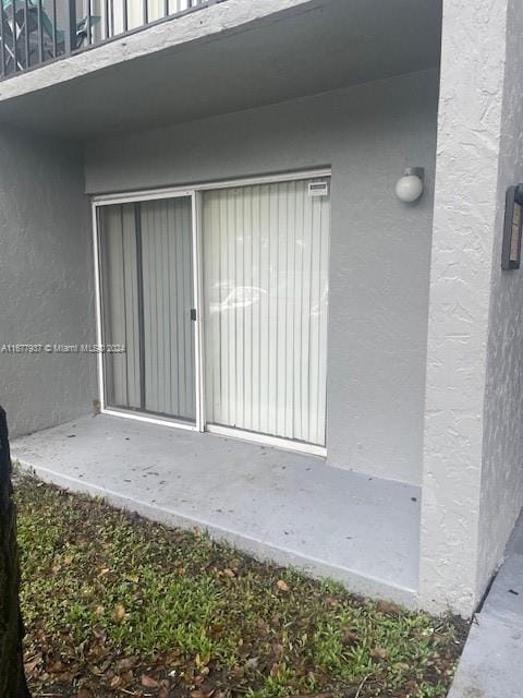 1068NBENOIST Farm Rd Unit 105, West Palm Beach, FL 33411 - doorway to property with a balcony and stucco siding
