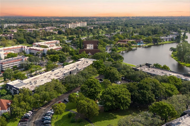 aerial view at dusk featuring a water view