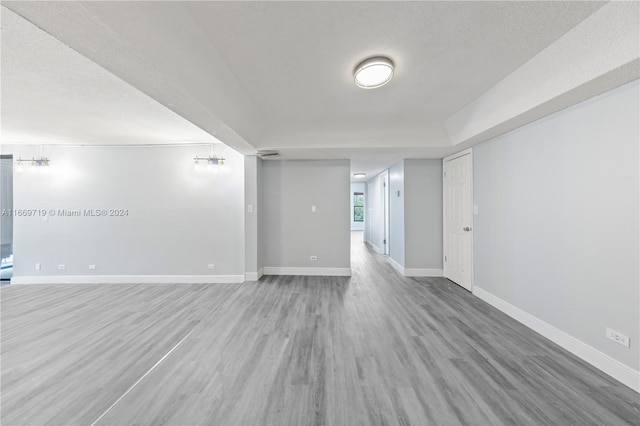 spare room featuring wood-type flooring and a textured ceiling