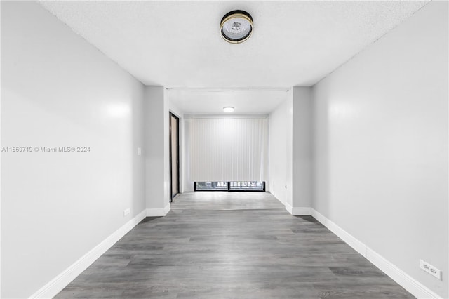 hall featuring a textured ceiling and dark hardwood / wood-style flooring