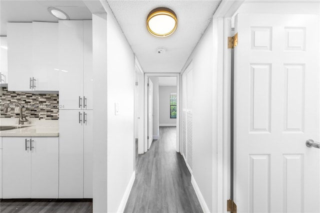 hall with sink, dark hardwood / wood-style floors, and a textured ceiling