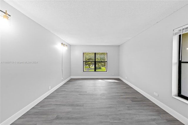 unfurnished room with a textured ceiling and hardwood / wood-style floors