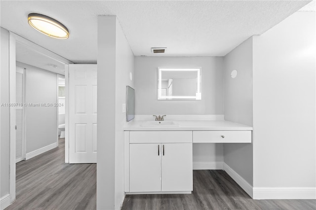 bathroom with toilet, a textured ceiling, vanity, and wood-type flooring