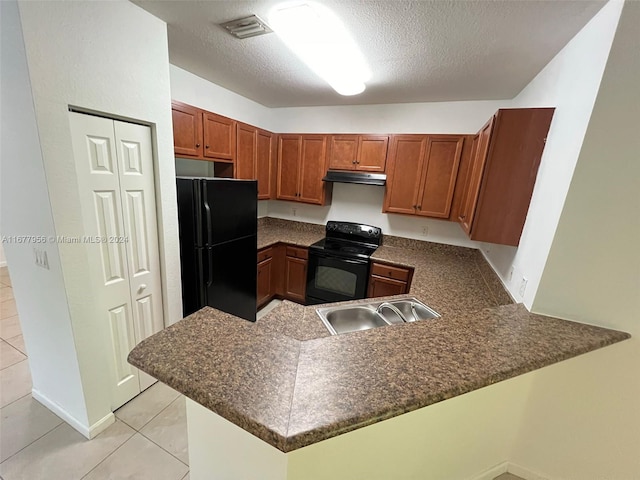 kitchen with kitchen peninsula, sink, black appliances, light tile patterned flooring, and a textured ceiling